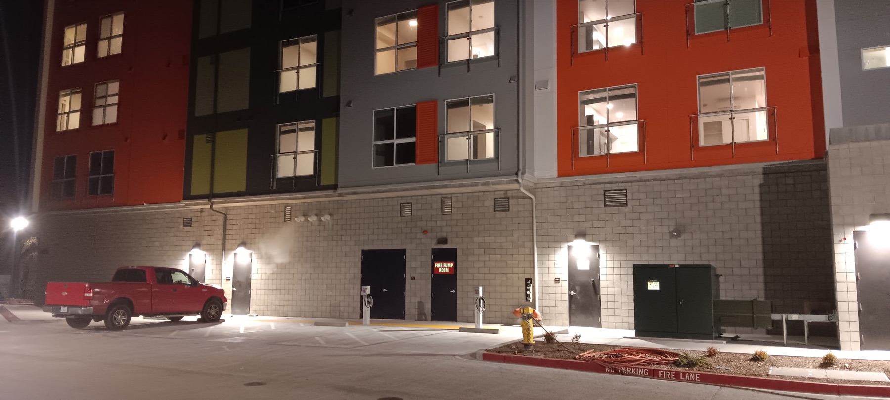 Exterior of a multistory apartment building with nighttime lighting