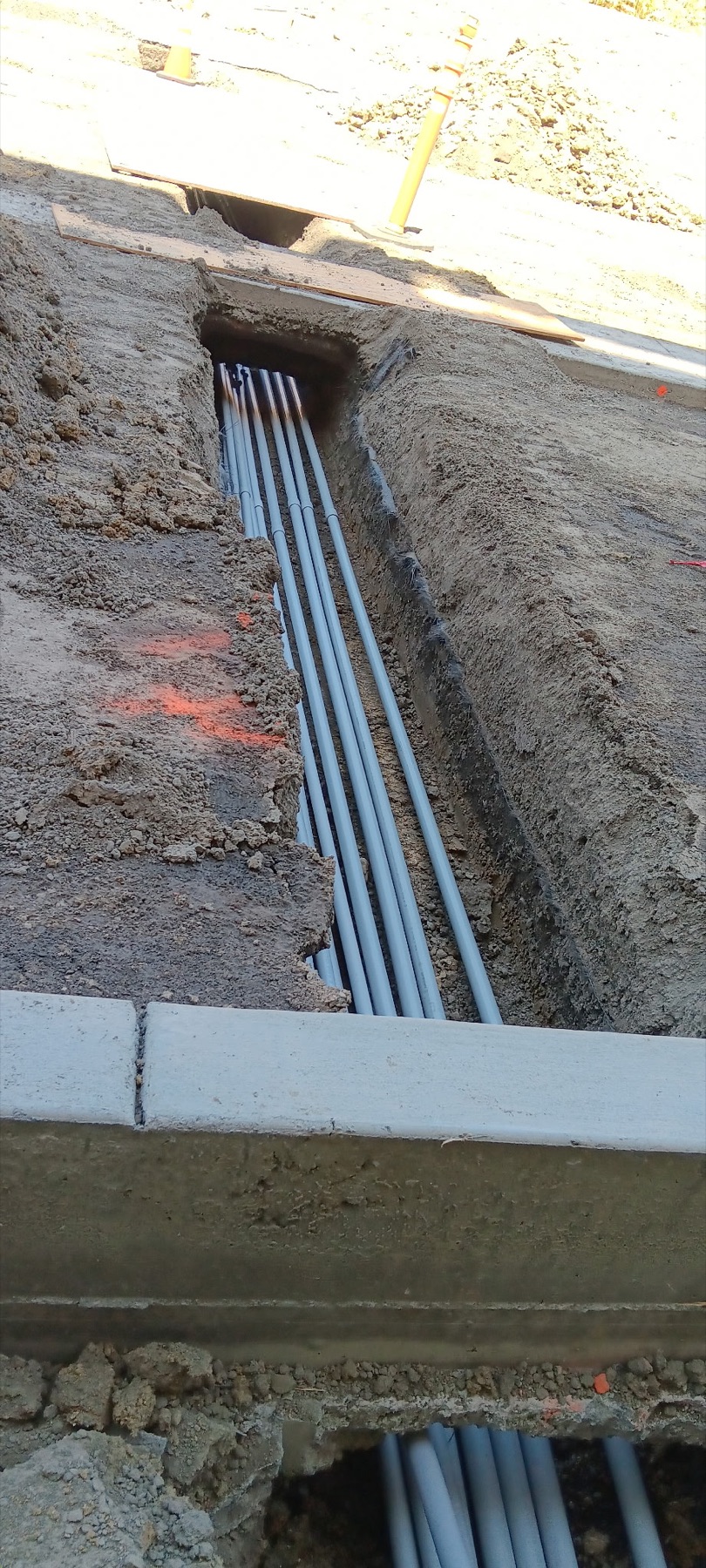Parallel underground electrical conduits installed in an open trench